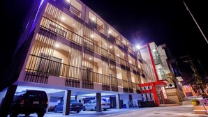 A multi-story hotel with a modern design, featuring balconies and a parking garage. - Smile Place Hotel Chiang Rai (Chiang Rai)