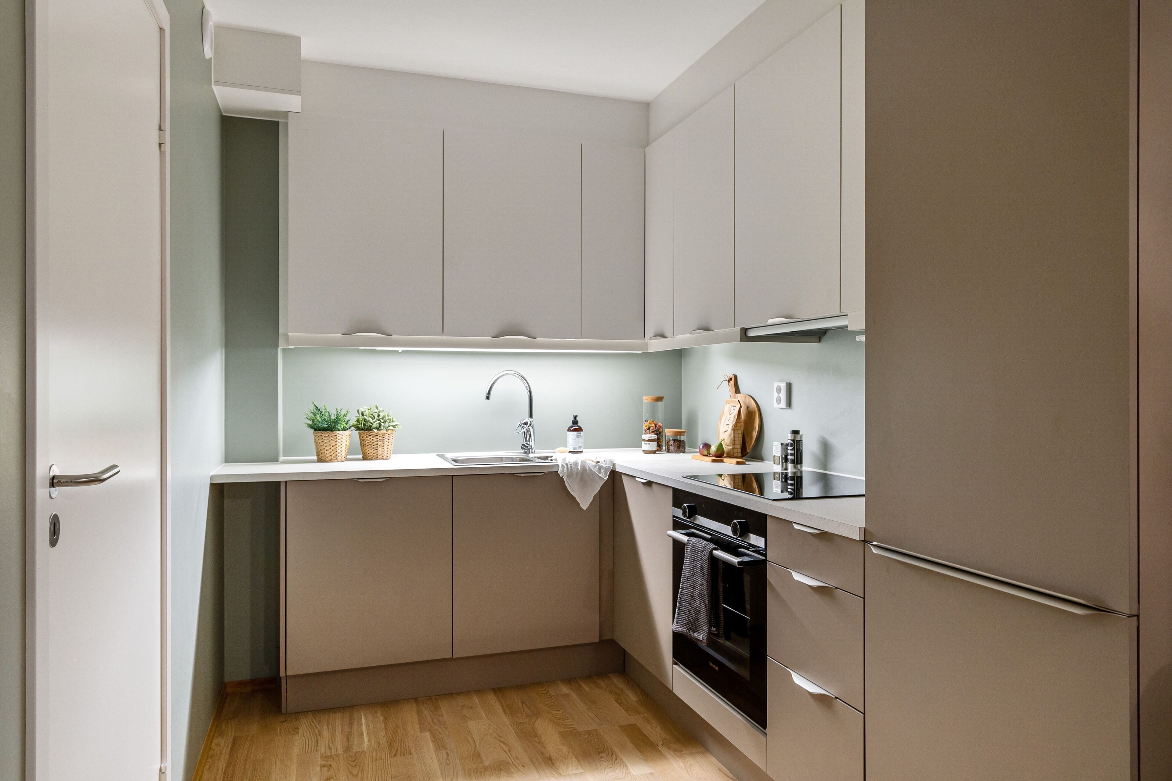 A compact kitchen with a sink, stove, and cabinets.