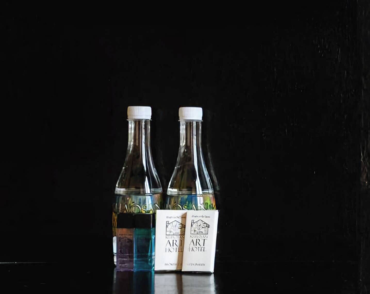Two bottles with labels against a dark background.
