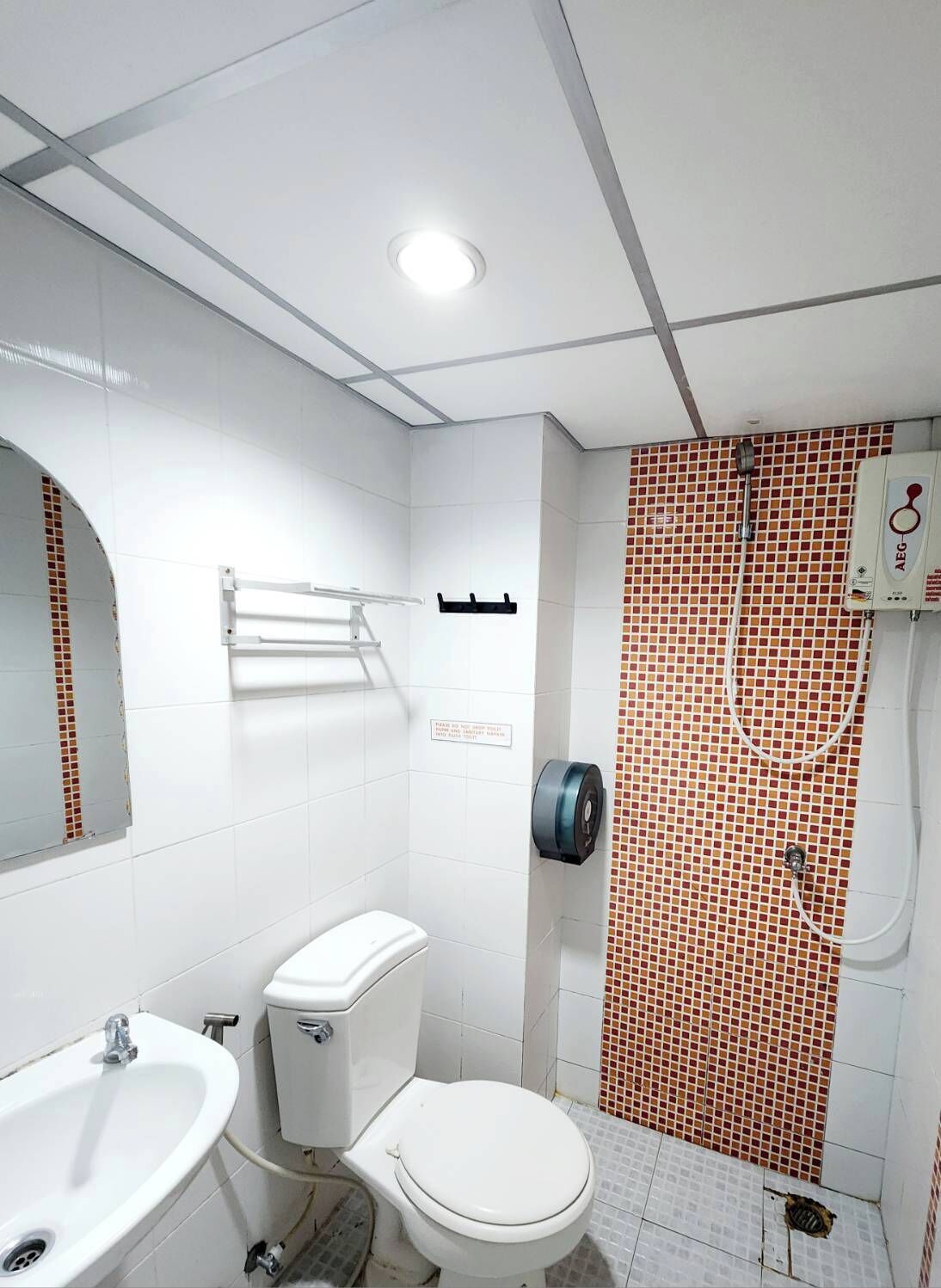 Une salle de bain comprenant des toilettes, un lavabo et un espace douche.