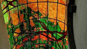 A stained glass window with a geometric pattern and a central circular design.
