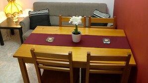 A dining table with a flower vase, two candles, and a red placemat. - The Yellow House 3 :) (Porto)
