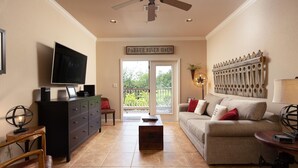 A living room with a television, a sofa, a coffee table, and a fireplace. - Parker River Haus Vg106 3 Bedroom Condo by RedAwning (New Braunfels)