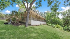 A two-story house with a covered porch and a well-maintained lawn. - Guadalupe River Rock Retreat 9740 by RedAwning (New Braunfels)