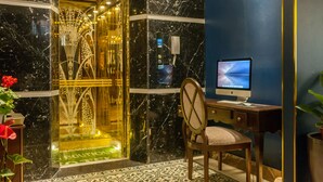 A hotel lobby with a marble floor, a desk with a computer, and a decorative glass door. - Eden Boutique Hotel & Spa (Sa Pa)