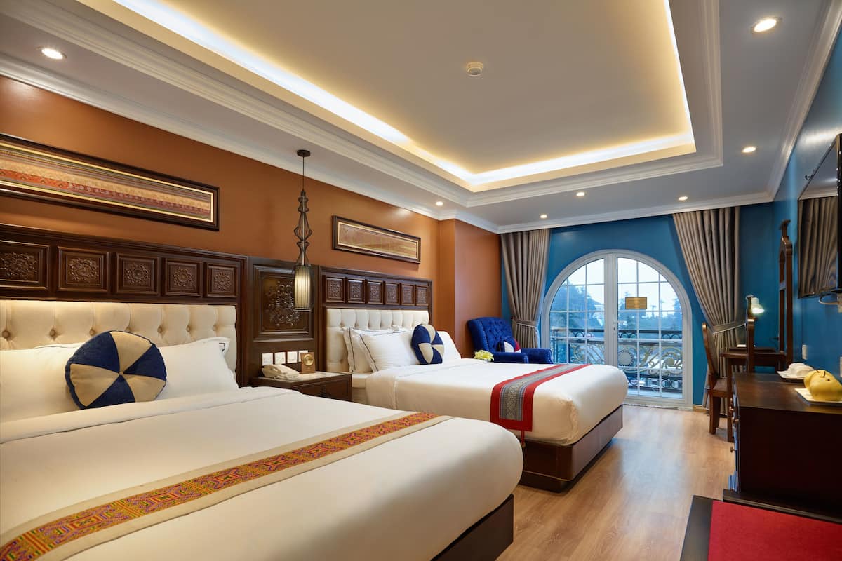 Een hotelkamer met twee bedden, een groot raam met uitzicht en een balkon.