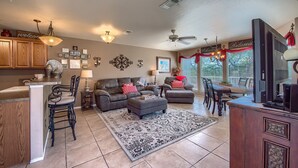 A spacious living room with a large rug, a fireplace, and a television.