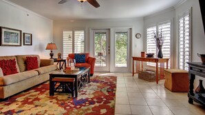 A living room with a sofa, coffee table, and a ceiling fan. - Guadalupe River Nut House   Ww I203 2 Bedroom Condo by RedAwning (New Braunfels)