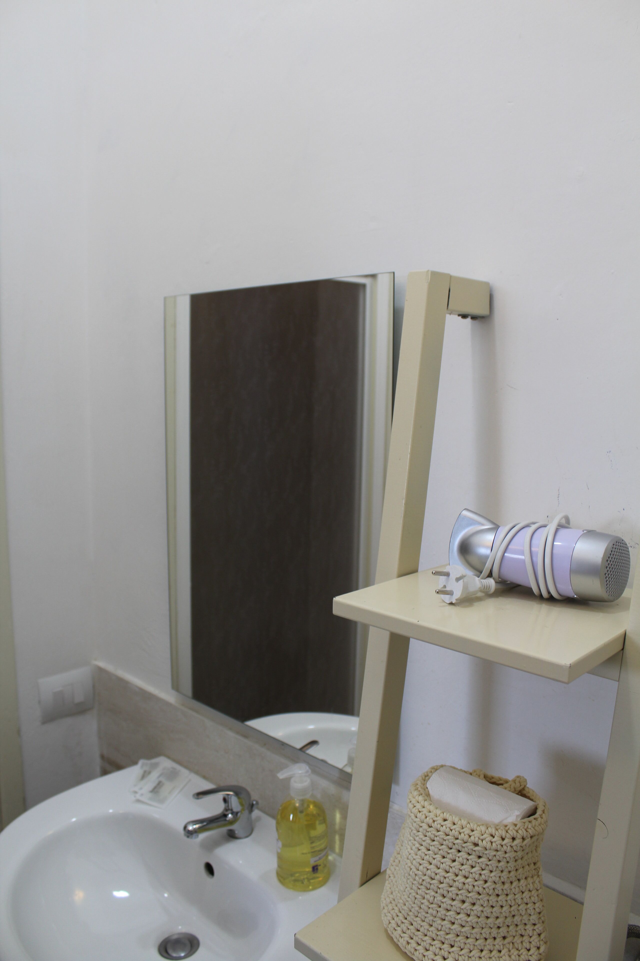 Une salle de bain équipée d’un lavabo, d’un miroir et d’un porte-serviettes.