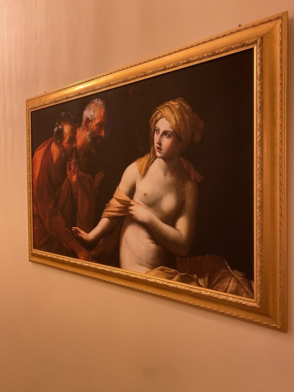 A classical painting with a gold frame, depicting a seated woman and a standing man, both in traditional attire. - Guesthouse Maria Francesca (Naples)