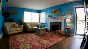 A living room with a blue wall, a beige sofa, a coffee table, and a fireplace.