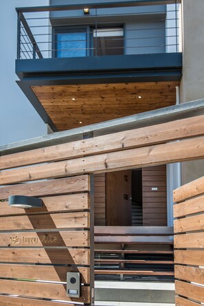 Un bâtiment moderne doté d’une façade en bois, d’un balcon et d’une entrée bien visible.