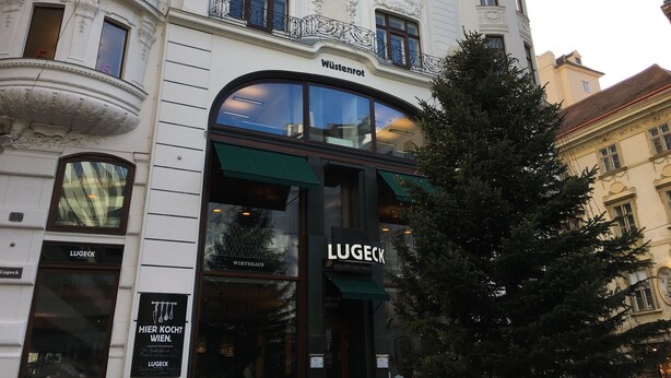 A historic building with ornate architectural details, including a balcony with intricate carvings and a large arched window. - City-center apartment (Vienna)