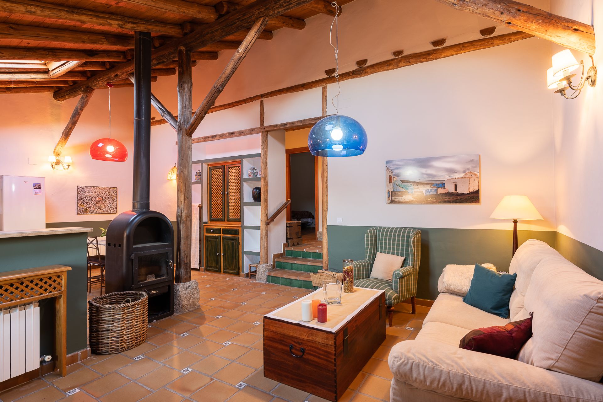 Un salon chaleureux avec une cheminée, un canapé, une table basse et une vue sur l’extérieur.