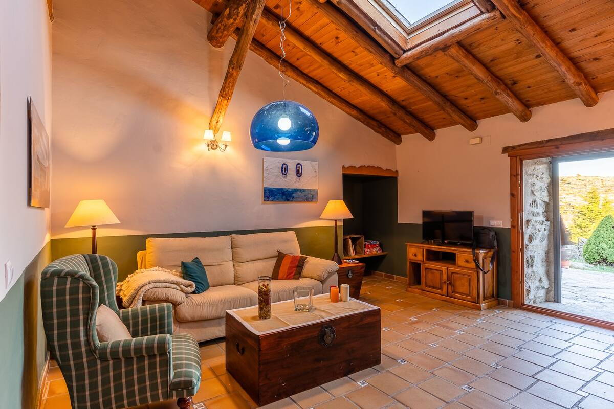 Un salon confortable avec un canapé, des fauteuils, une table basse et un meuble pour la télévision.