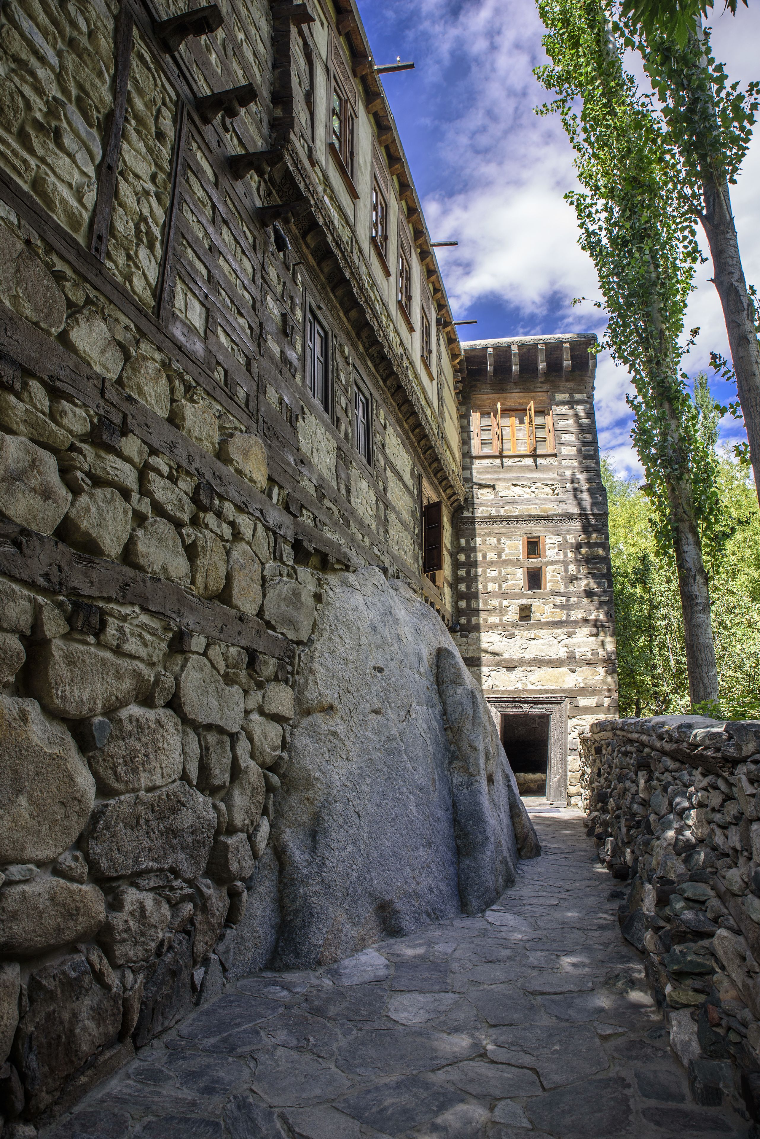 A stone building with a narrow stone pathway leading to a door.