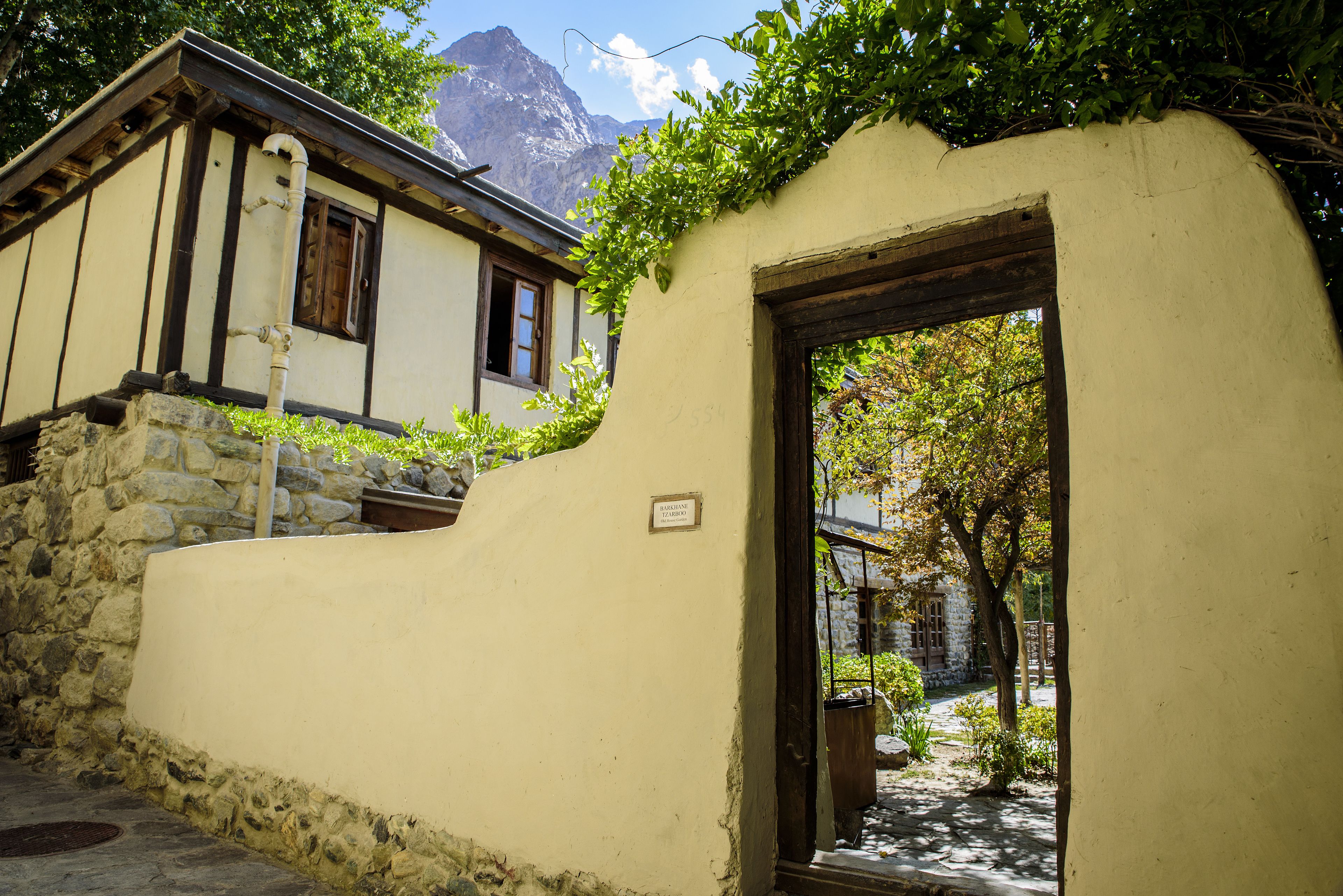 Un edificio tradicional con base de piedra, puerta de madera y una ventana pequeña.