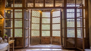Una habitación tradicional con paredes y suelo de madera, un futón de tatami y una puerta corredera de papel de arroz.