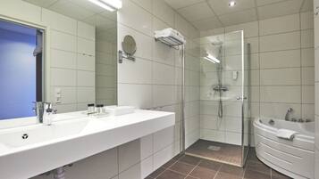 A modern bathroom with a large mirror, a sink, a shower, and a bathtub.