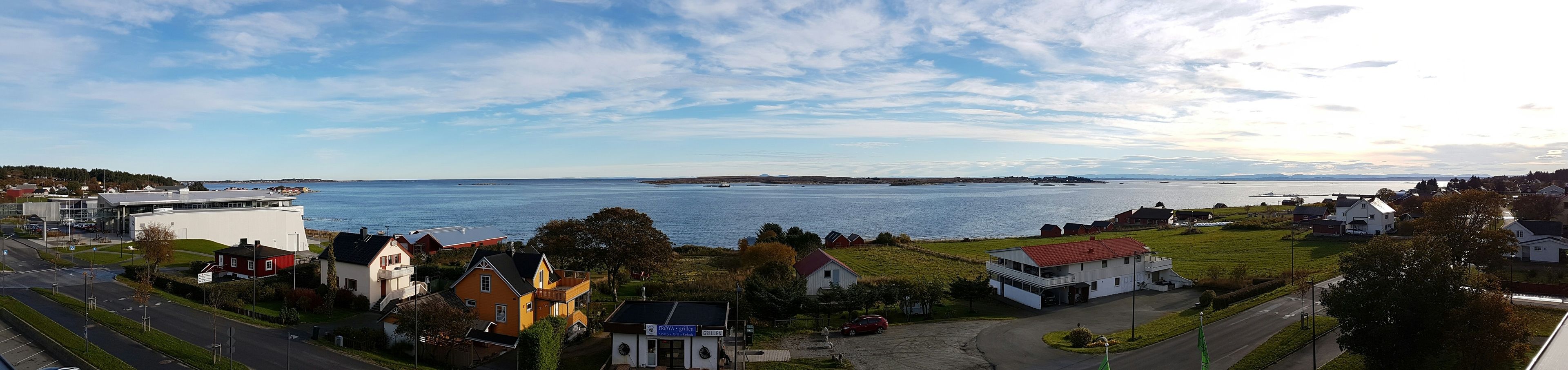 Un pueblo costero con vista al mar, casas y un restaurante llamado 'FROYA Grillen'.