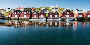 A waterfront with red buildings and boats. - Hotell Frøya (Frøya)