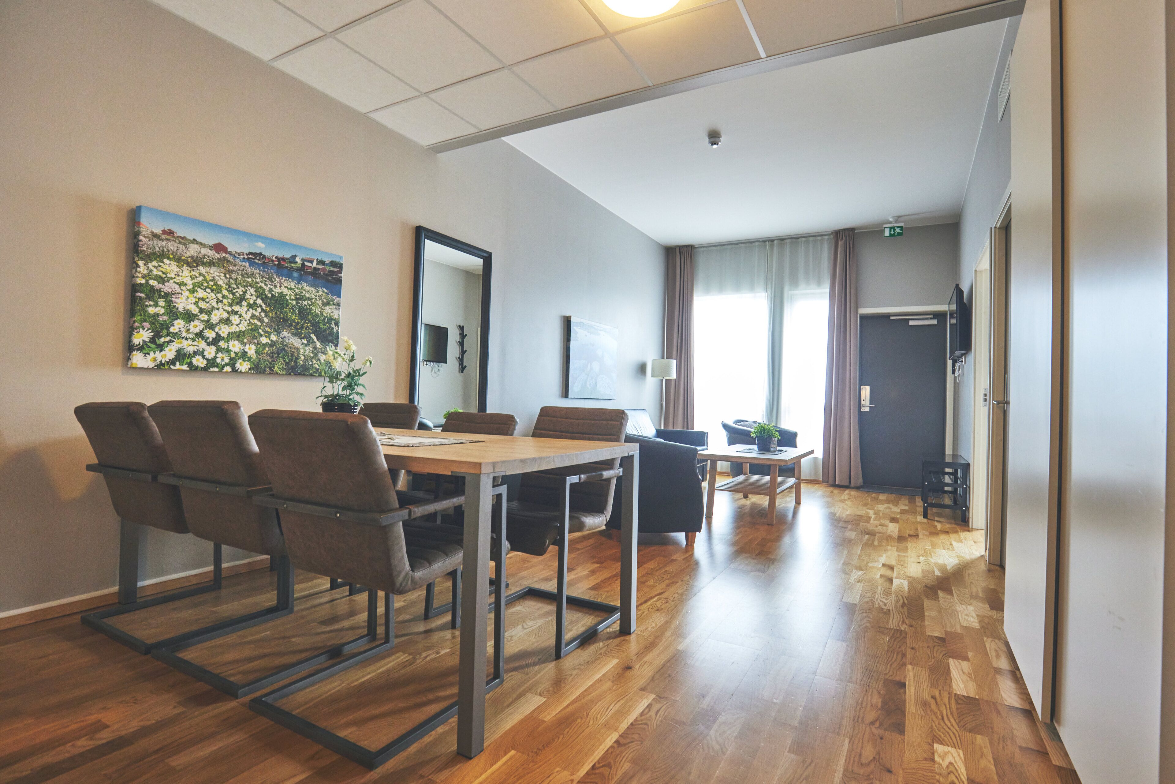 A conference room with a wooden table, chairs, and a painting on the wall.