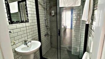 Ein Badezimmer mit Duschkabine, Waschbecken und Toilette.