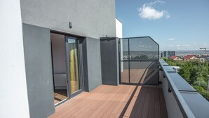 A balcony with a wooden floor, a glass door, and a view of the cityscape. - UBA Accommodation (Cluj-Napoca)