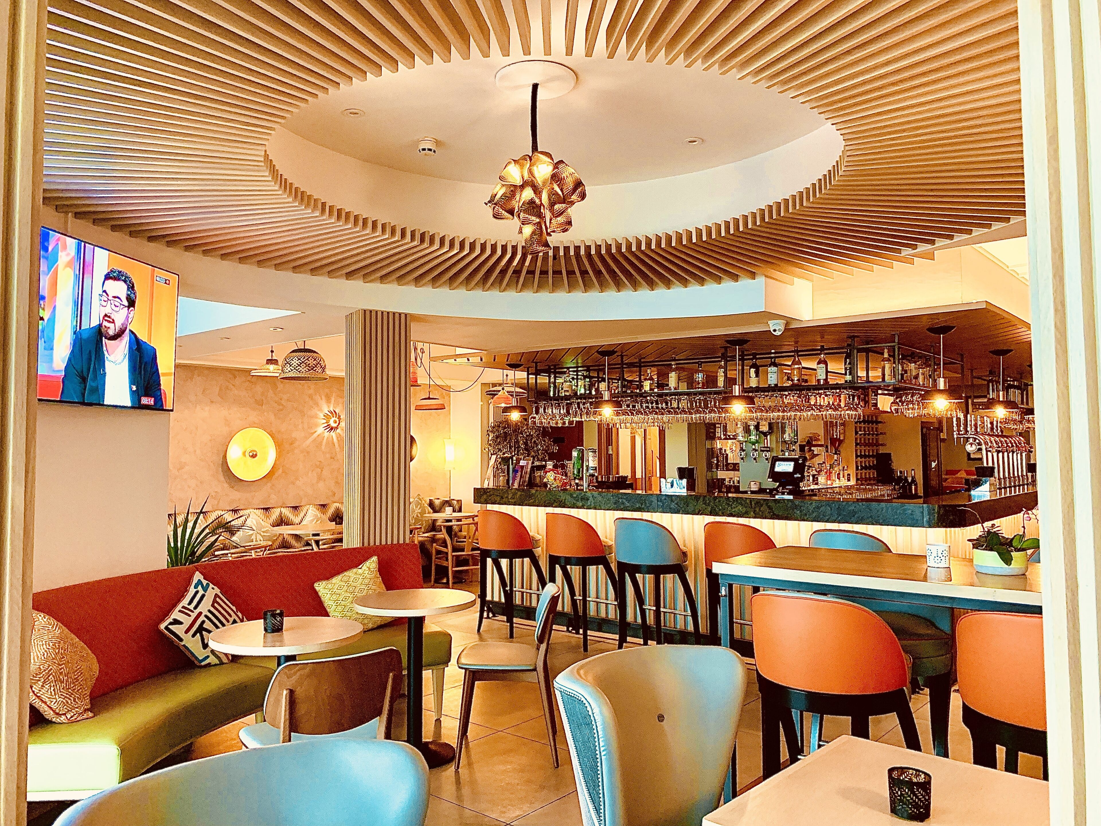 A bar area with seating and a television screen.
