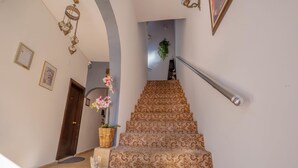 Eine Treppe mit gemustertem Teppich, die zu einer Zwischenebene führt.