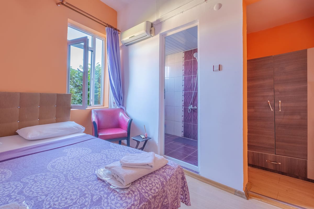 Une chambre à coucher comprenant un lit, une chaise, une petite table et une armoire.