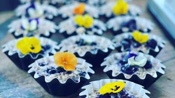 A tray of cupcakes with decorative flowers on a wooden surface.