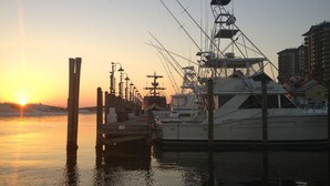A marina with boats docked, a clear sky, and a sunset. - Summer Breeze 103:  Stay seaside at our 1-bedroom Miramar Beach condo! (Miramar Beach)