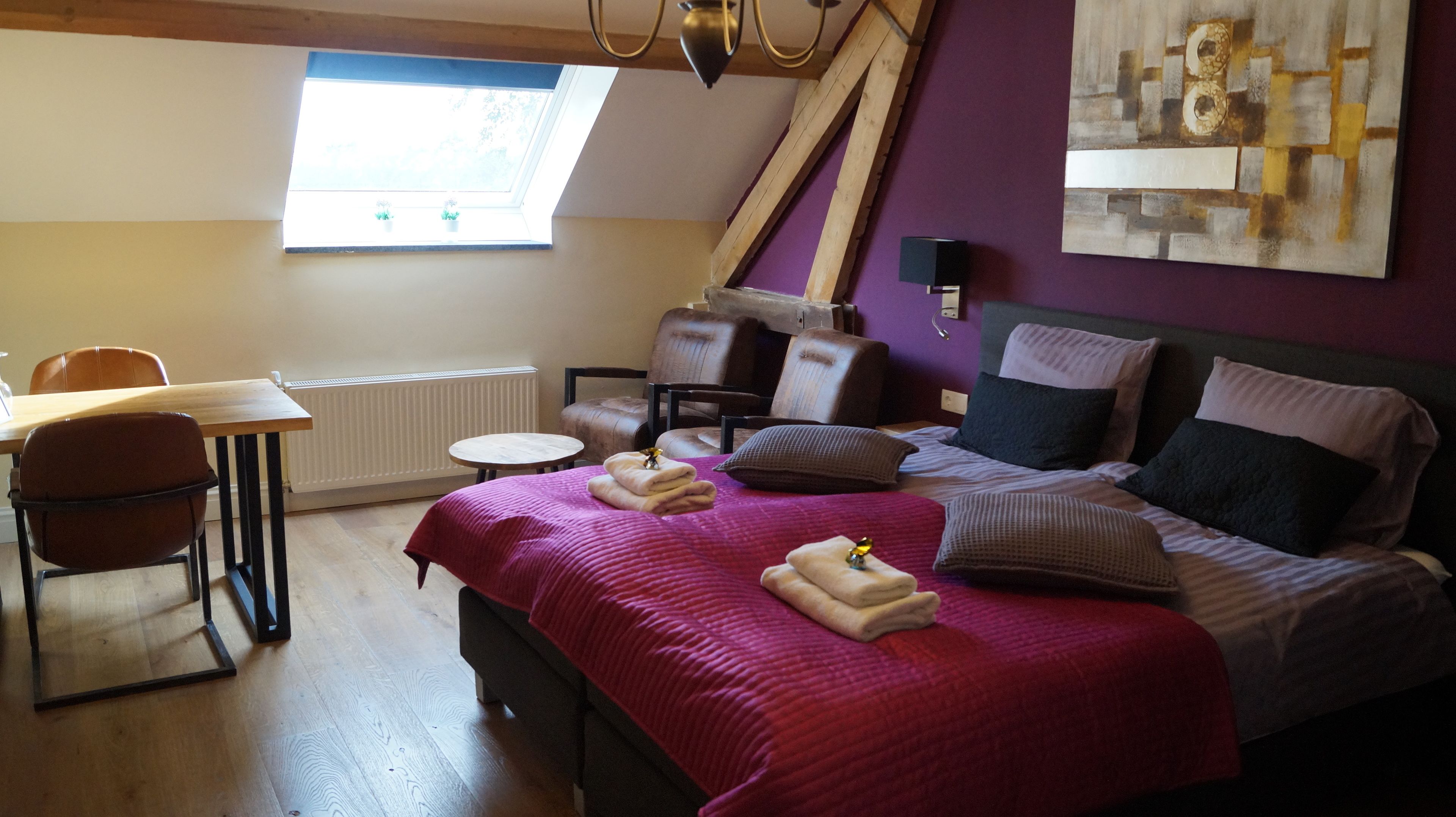 A bedroom with a bed, a desk, a chair, a radiator, and a window.