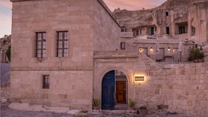 A stone building with a blue door and a sign that reads "Serrin 6". - Serinn House (Urgup)