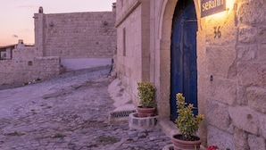 A stone building with a blue door and a sign that reads "serinn". - Serinn House (Urgup)