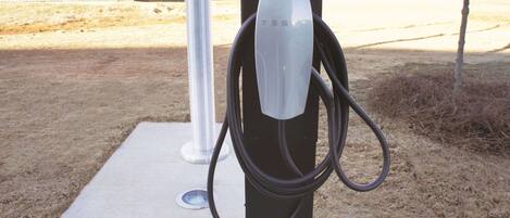 A Tesla electric vehicle charging station in an outdoor setting.