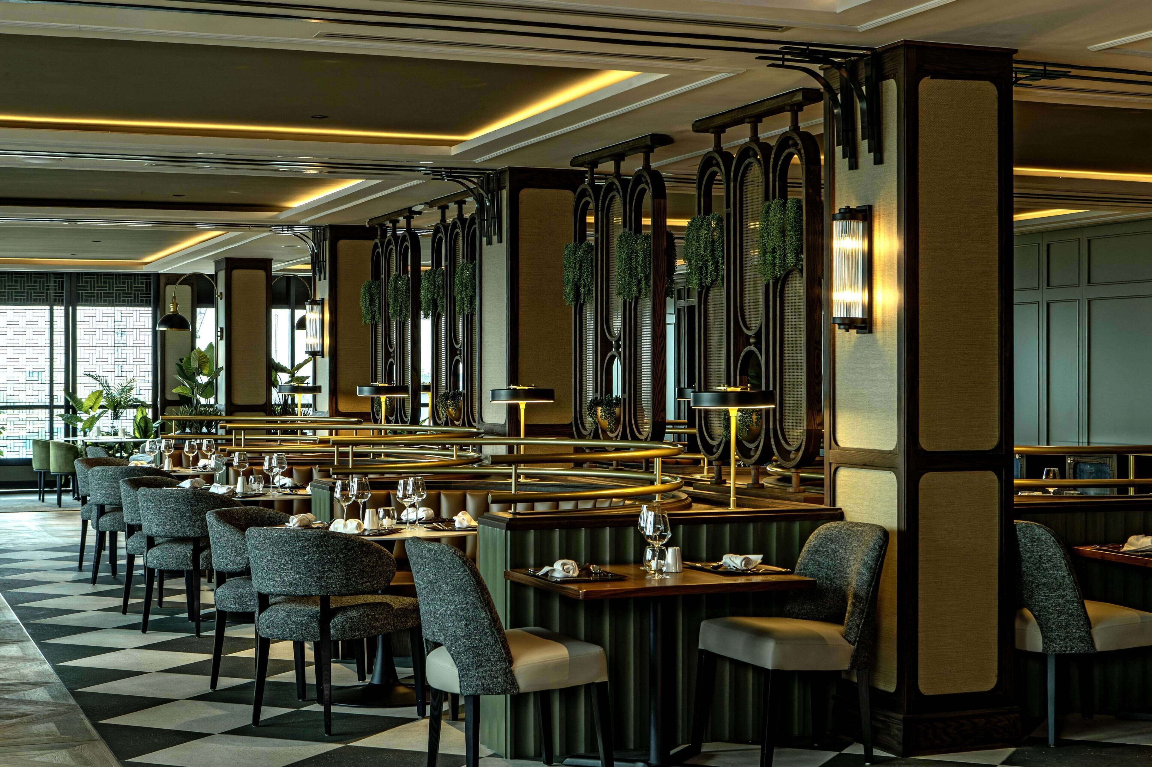 A restaurant with a checkered floor, round tables, and chairs.