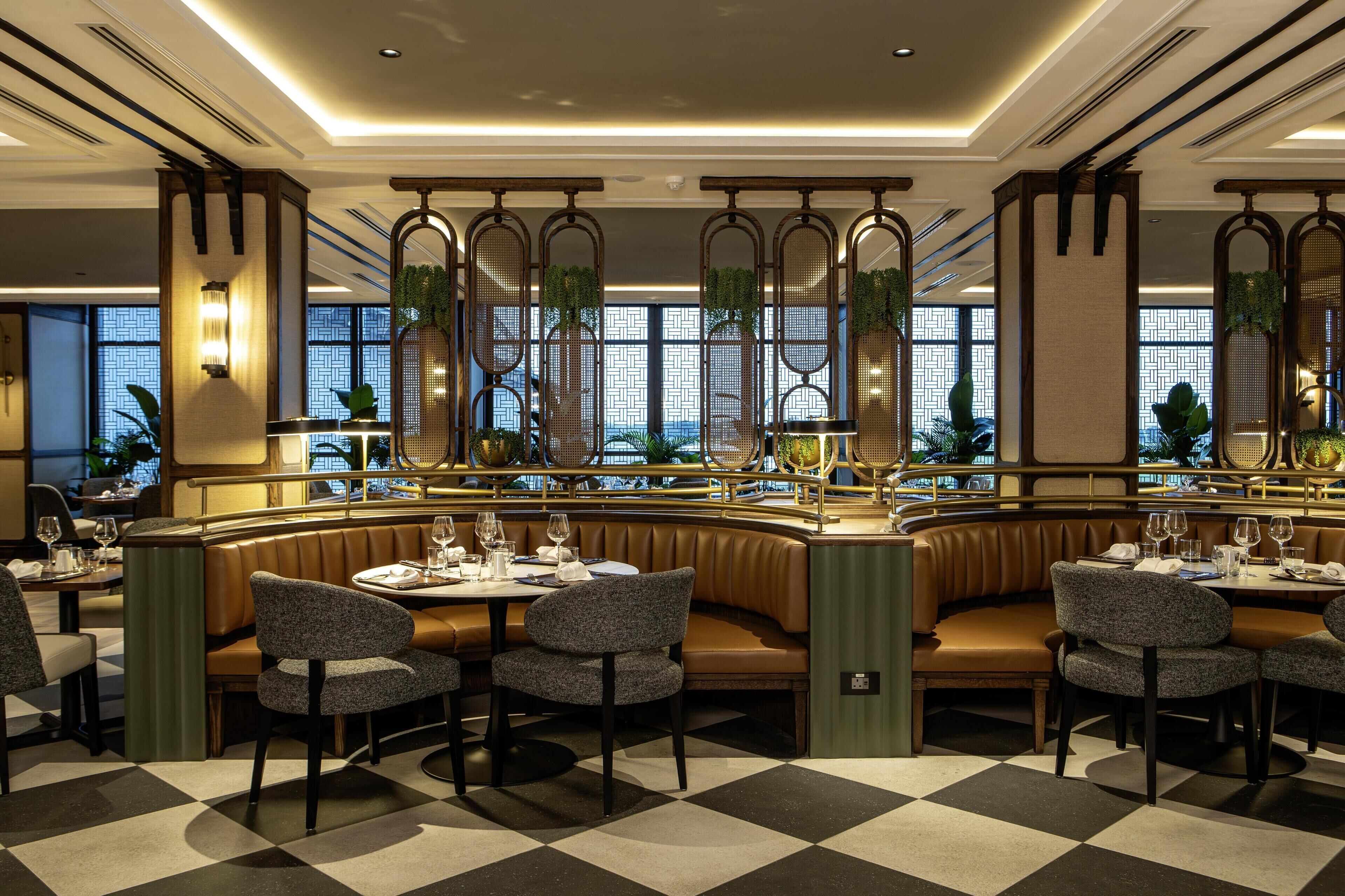 A restaurant with a checkered floor, booths, and a bar area.