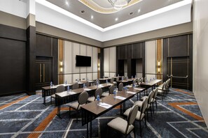 A conference room with long tables, chairs, water bottles, and a flat-screen TV. - Legend Hotel Lagos Airport, Curio Collection by Hilton (Lagos)