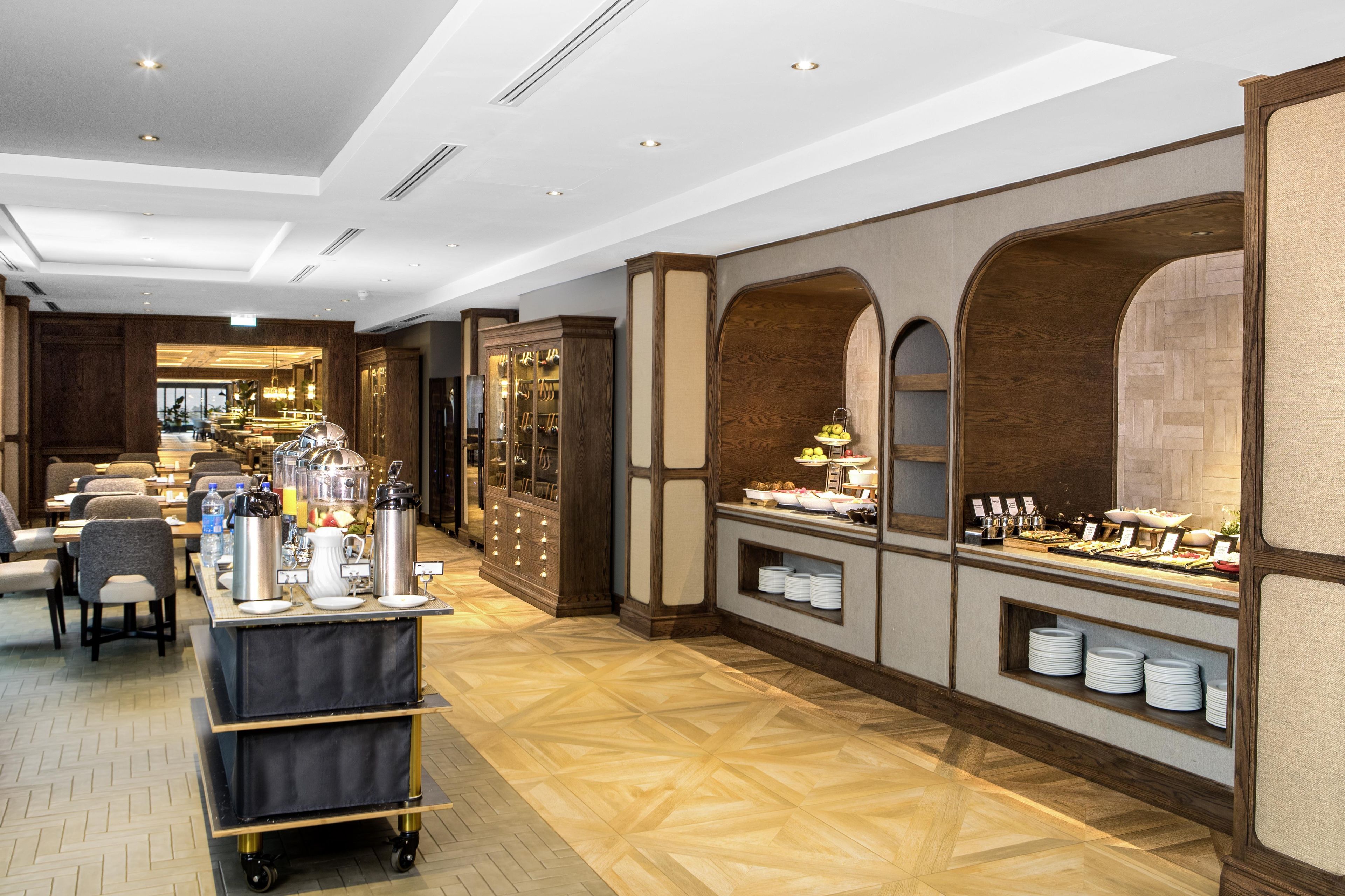 A hotel lobby with a buffet area, seating, and a reception desk.