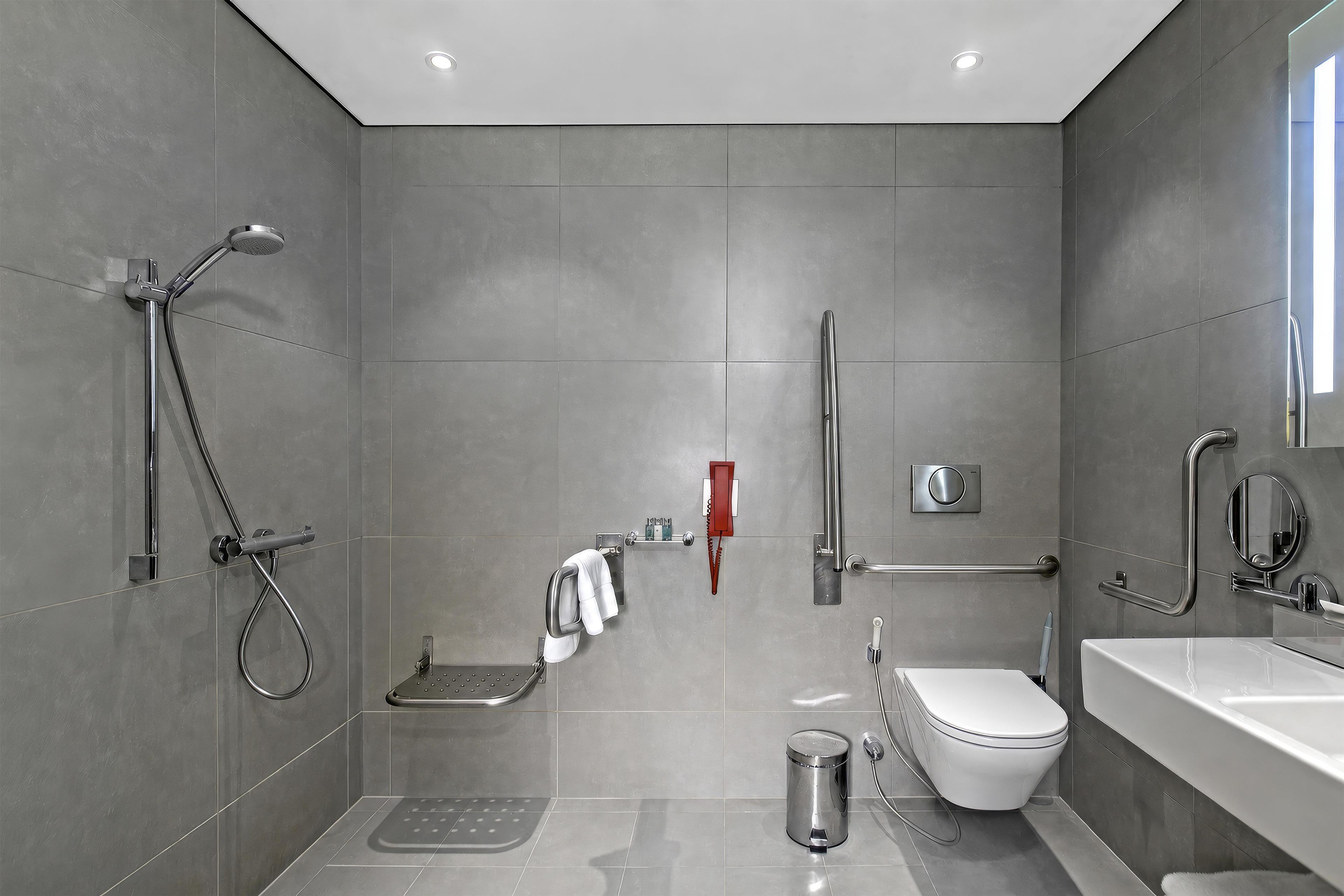 A modern bathroom with a shower, toilet, and sink.