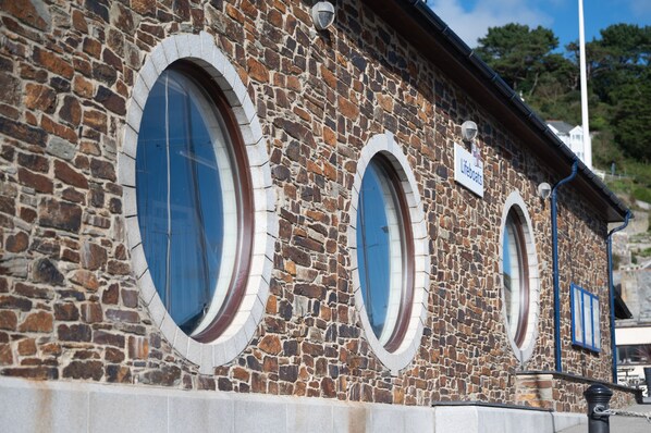 Un edificio de piedra con ventanas arqueadas y un letrero que dice "lifeboats".