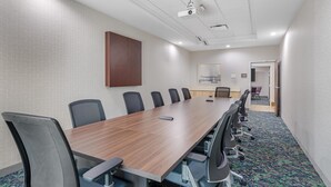 A conference room with a long table, multiple chairs, a projector, and a carpeted floor. - Home2 Suites by Hilton Dallas DeSoto (DeSoto)