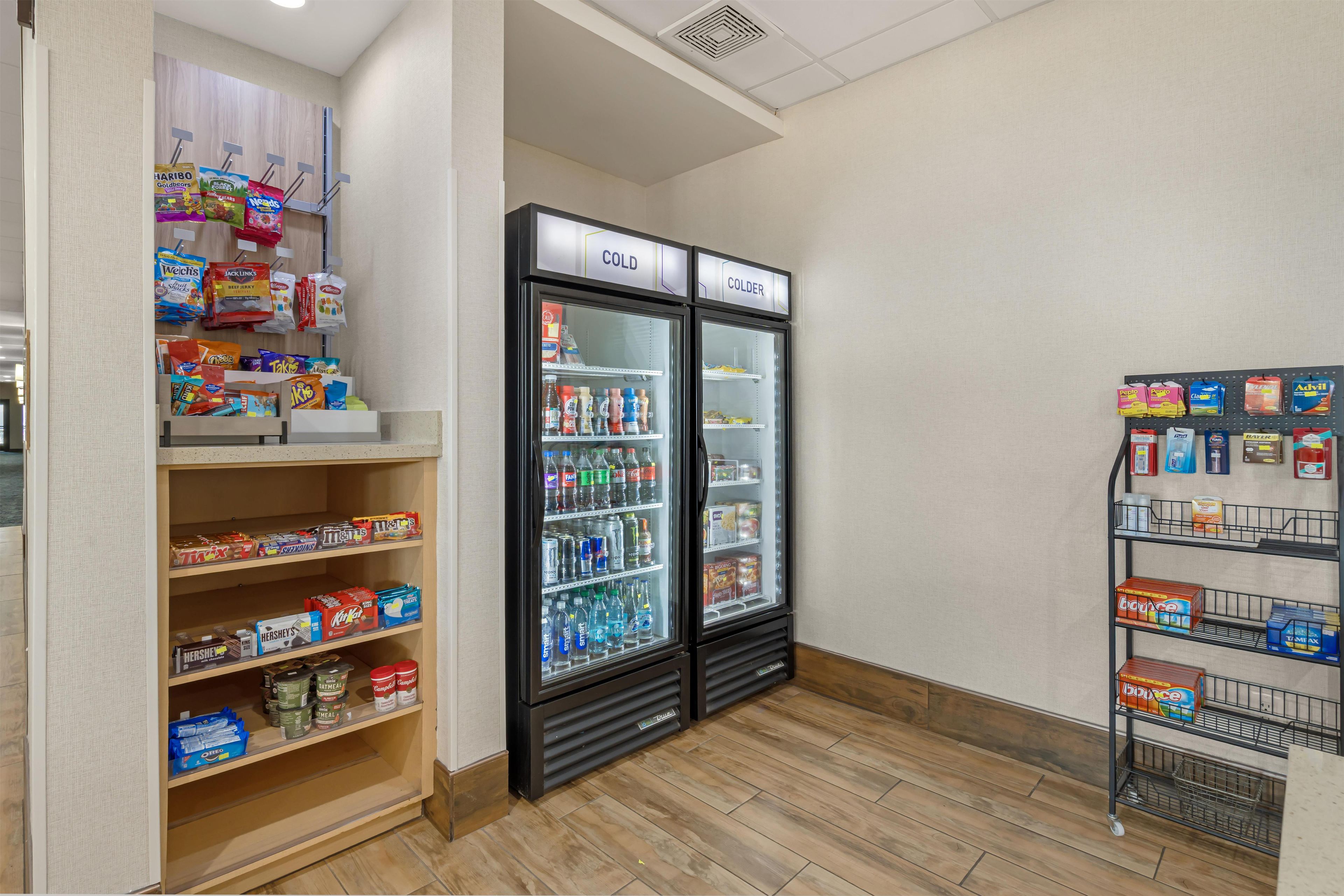 A snack and beverage section with shelves stocked with various snacks and a refrigerator with cold drinks.