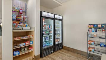 A snack and beverage section with shelves stocked with various snacks and a refrigerator with cold drinks.