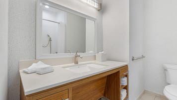 Un baño moderno con lavamanos doble, tocador de madera y un espejo grande.