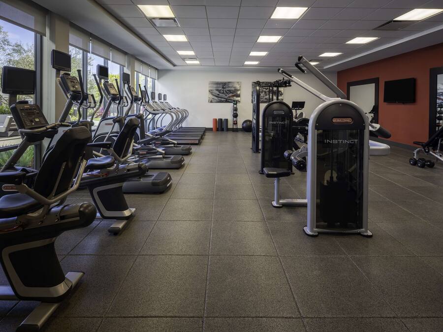 Una palestra con tapis roulant, macchinari ellittici e macchine per pesi.
