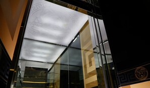 En moderne bygningsfacade med spejleffektglas og et geometrisk mønster.