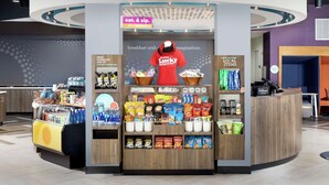 A 24/7 market area with a variety of snacks and beverages, a breakfast display, and a Hilton Honors counter. - Tru by Hilton Louisville East (Louisville)
